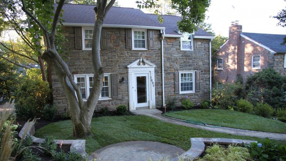 green grass, landscaped yard, house on a hill